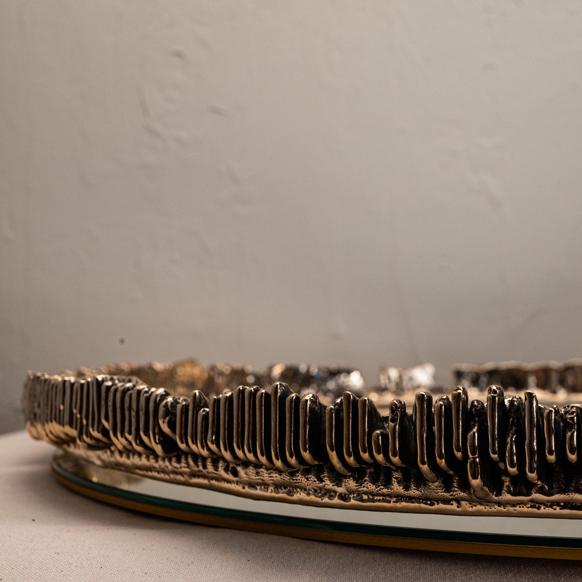Decorative mirror detailed view of metal textured edge on a neutral background