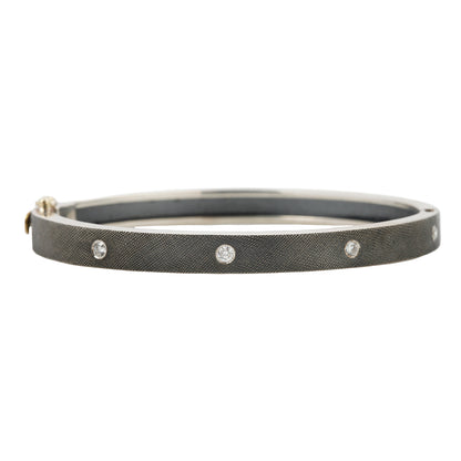 Rene Escobar - Silver bangle with diamonds on a white background