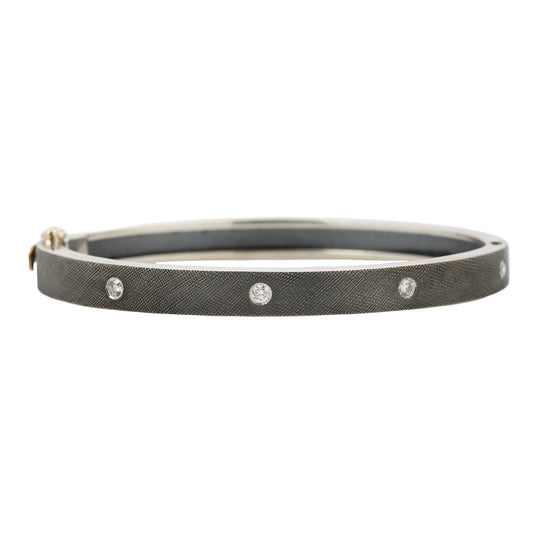 Rene Escobar - Silver bangle with diamonds on a white background