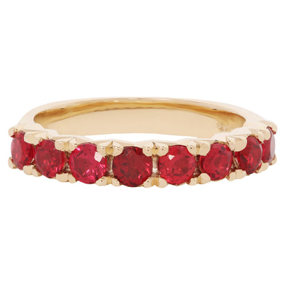 Gold ring with red gemstones on a white background