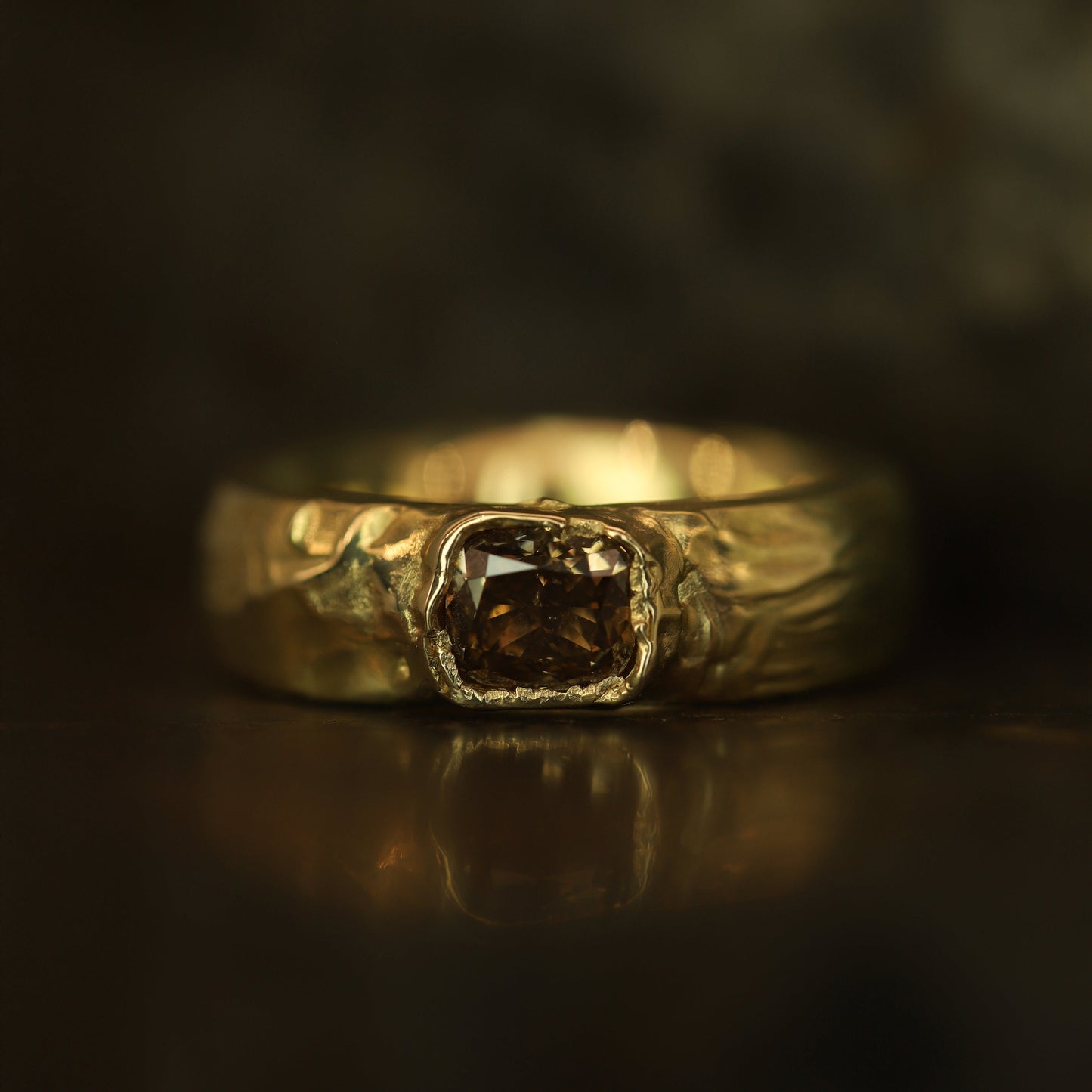 Gold ring with a central diamond on a dark background