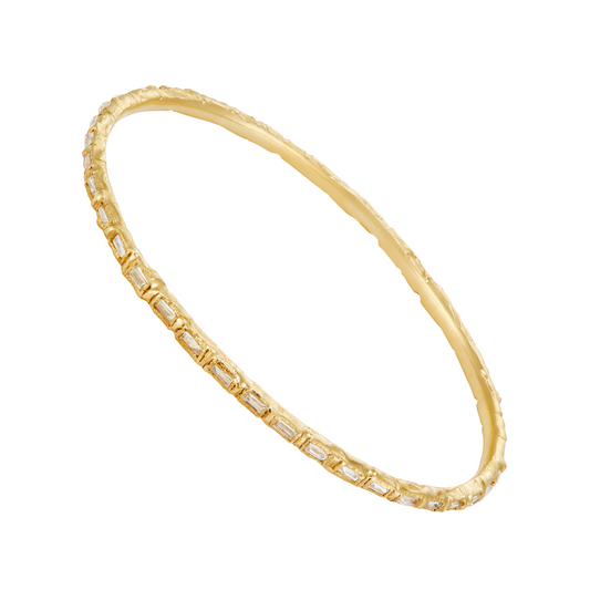 A gold bangle bracelet featuring a textured outer band and a smooth inner band paved with small rectangular clear stones, shown on a plain white background.