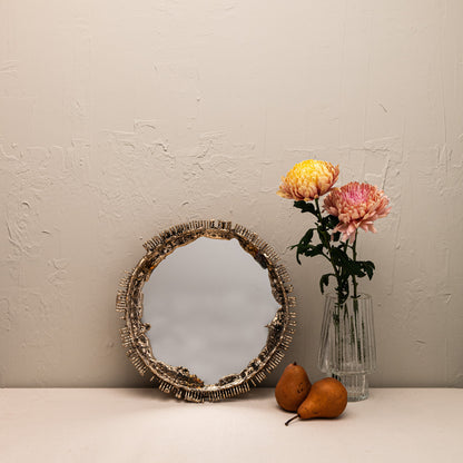 Decorative mirror with a vase of flowers and pears on a neutral background