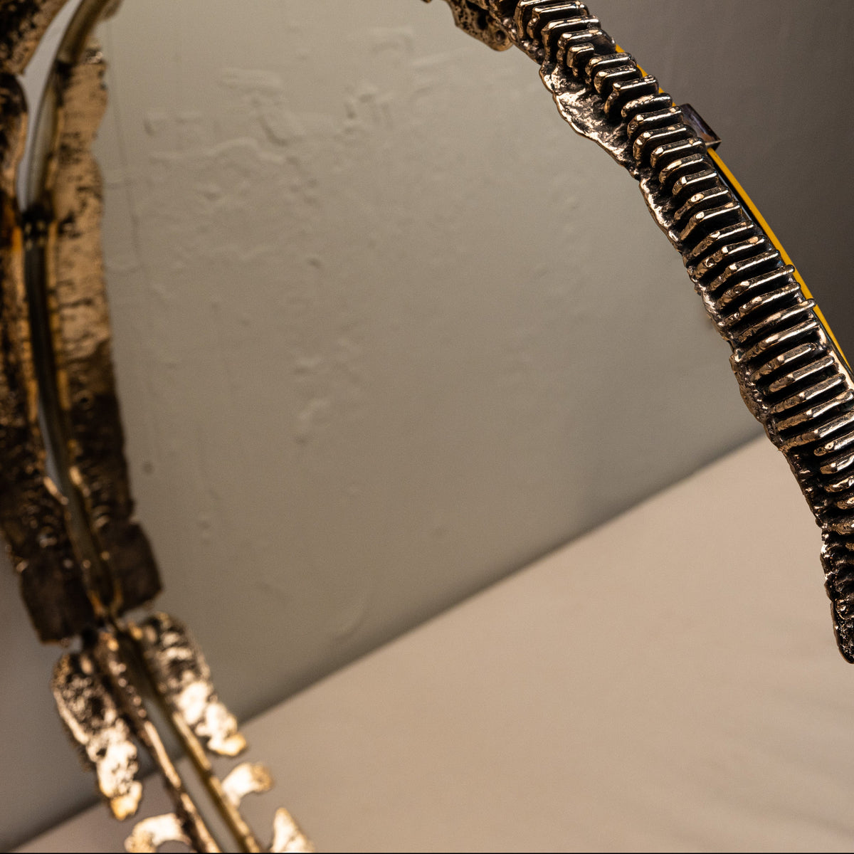 Close-up of a decorative mirror with intricate design on a plain background