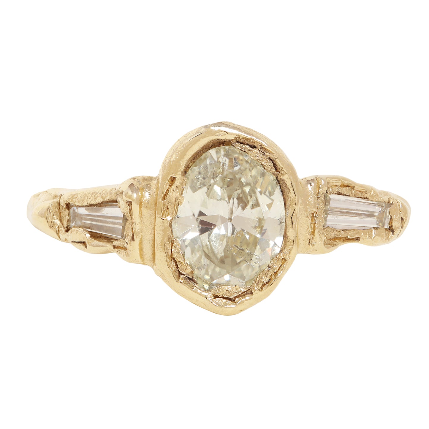 A yellow gold ring featuring a large oval-cut clear center stone and two baguette-cut side stones, shown on a plain white background.