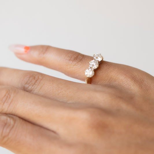 Diamond ring on a finger against a neutral background