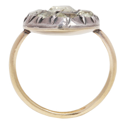 Antique ring with central gemstone and smaller green stones on a white background
