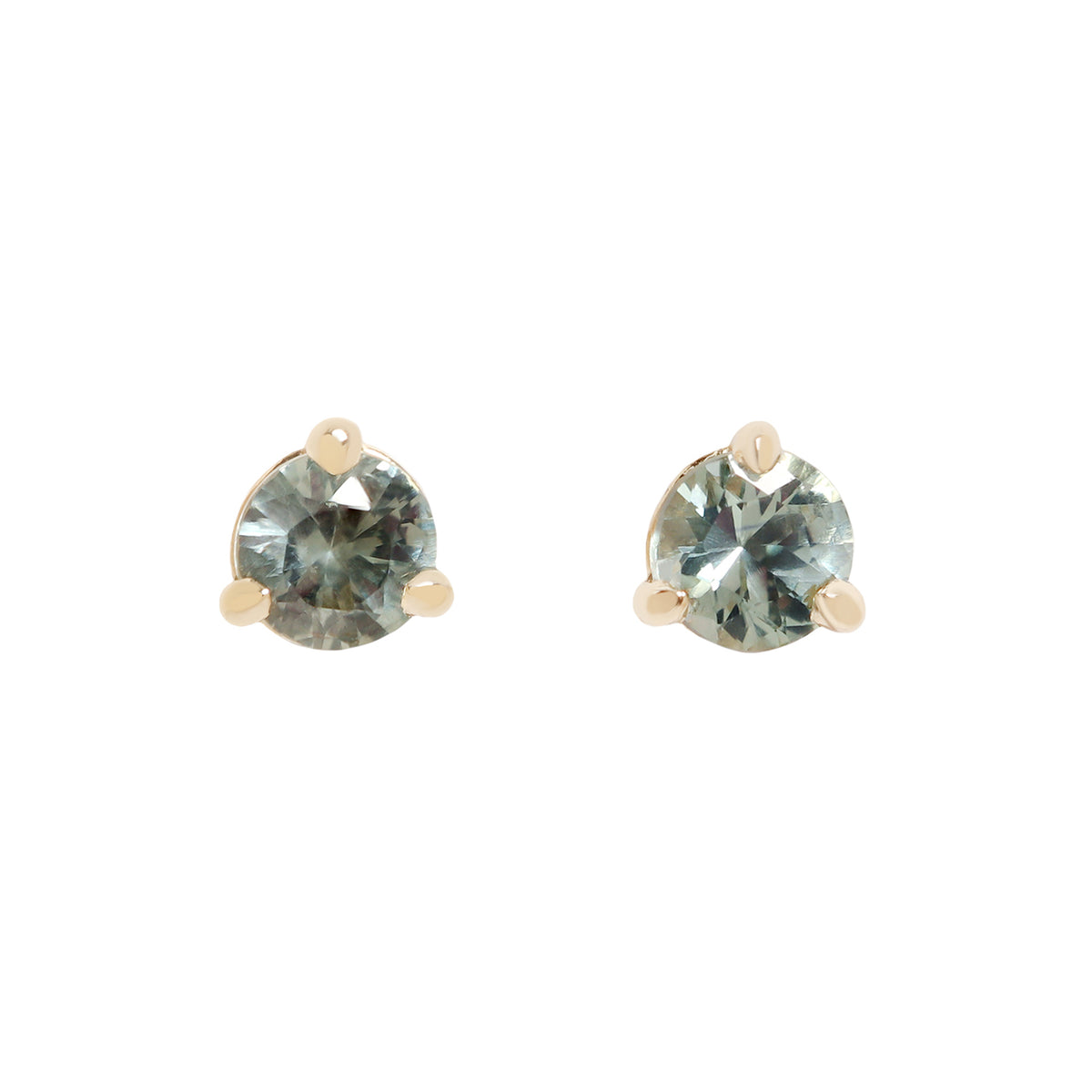 A pair of gold stud earrings with round-cut, faceted gray blue green gemstones, set in a three-prong setting against a plain white background.