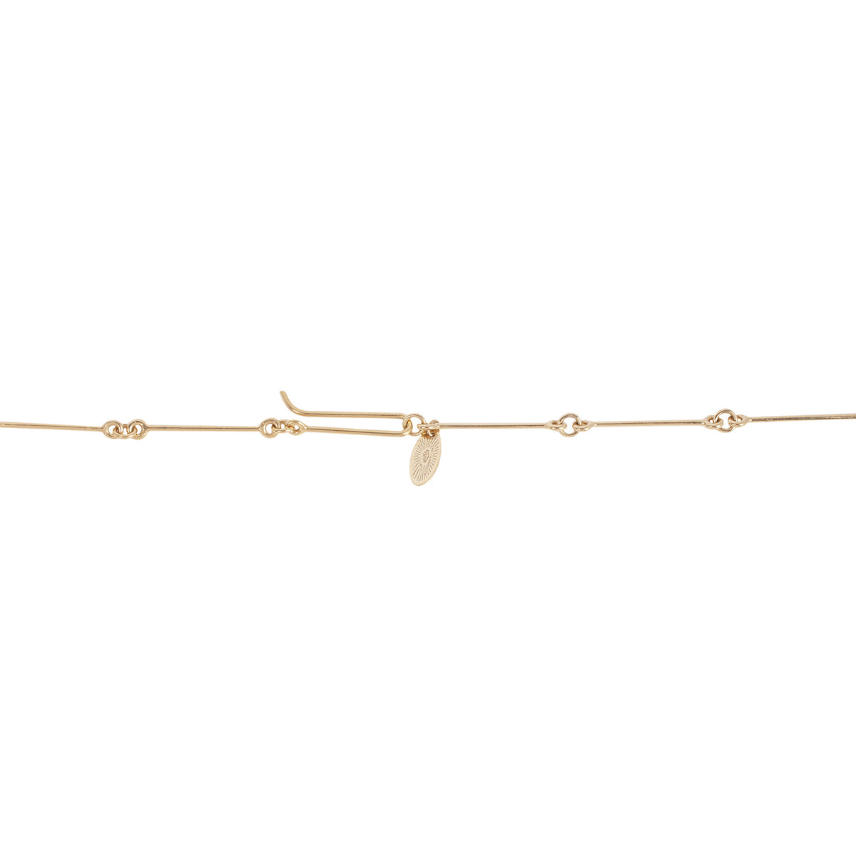 Gold chain with a small round charm on a white background