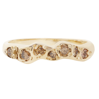 A gold ring featuring a wavy, organic-shaped band set with seven small round brown gemstones, shown against a plain white background.
