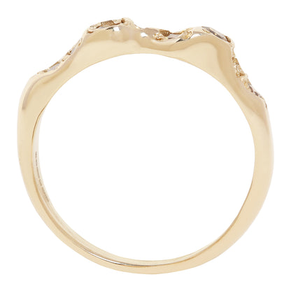 A gold ring with an organic, wavy, undulating top surface, photographed against a solid white background.