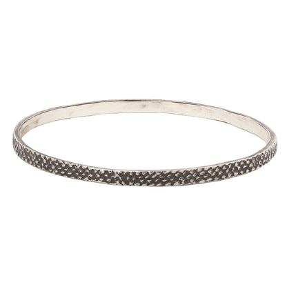silver bangle with textured, oxidized finish against a white backdrop - Lauren Wolf Jewelry | ESQUELETO
