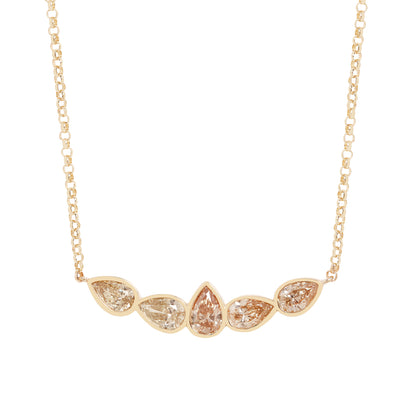 A gold necklace featuring five pear-cut clear gemstones in a row, with the center stone being teardrop-shaped. The stones are set in a yellow gold chain on a solid white background.