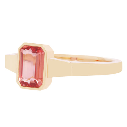 Gold ring with a pink gemstone on a white background