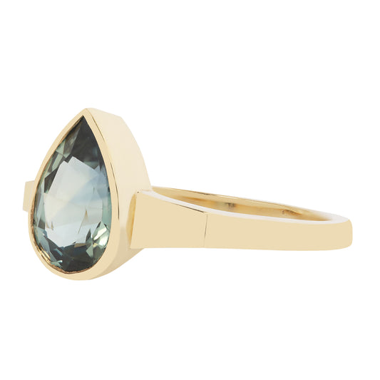 Gold ring with a green gemstone on a white background