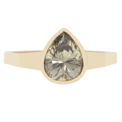 Gold ring with a large teardrop-shaped green diamond on a white background
