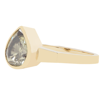 Gold ring with a large teardrop-shaped green diamond on a white background