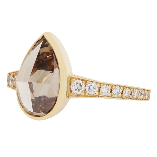Gold ring with a large brown gemstone and smaller diamonds on a white background