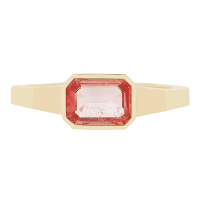 Gold ring with a pink gemstone on a white background