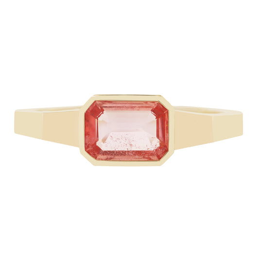 Gold ring with a pink gemstone on a white background