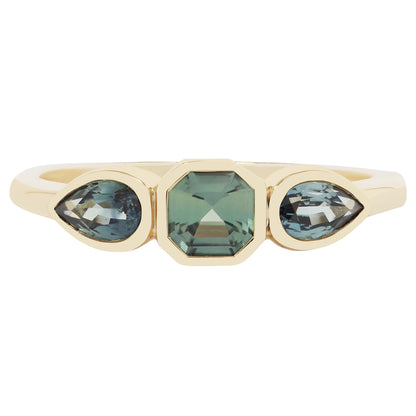 Gold ring with green gemstones on a white background
