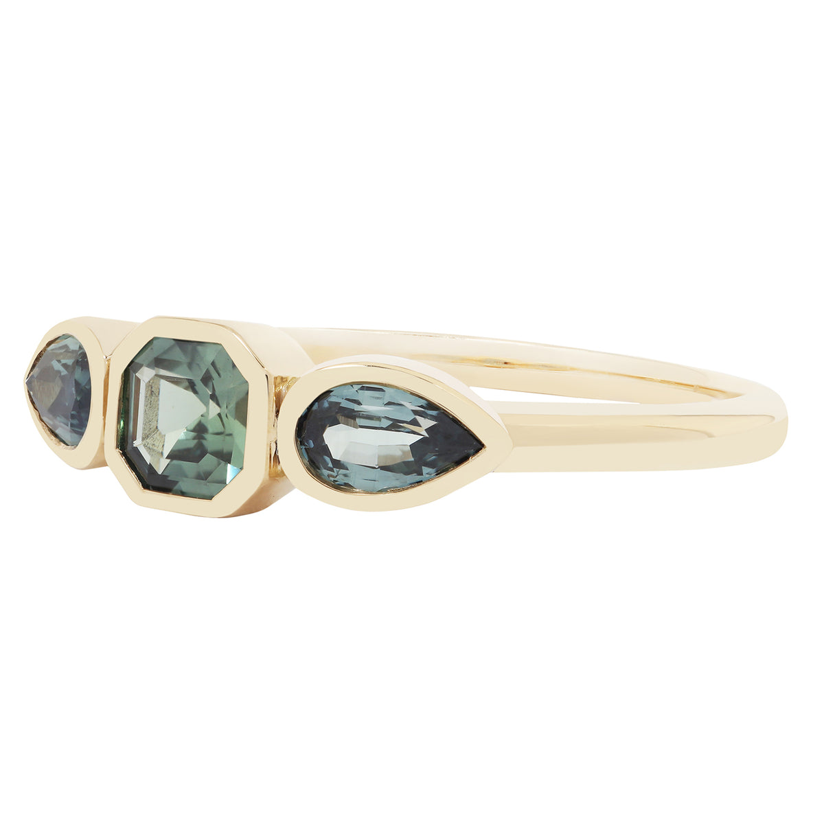 Gold ring with three green gemstones on a white background
