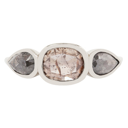 White gold ring with three pear-shaped gemstones on a white background