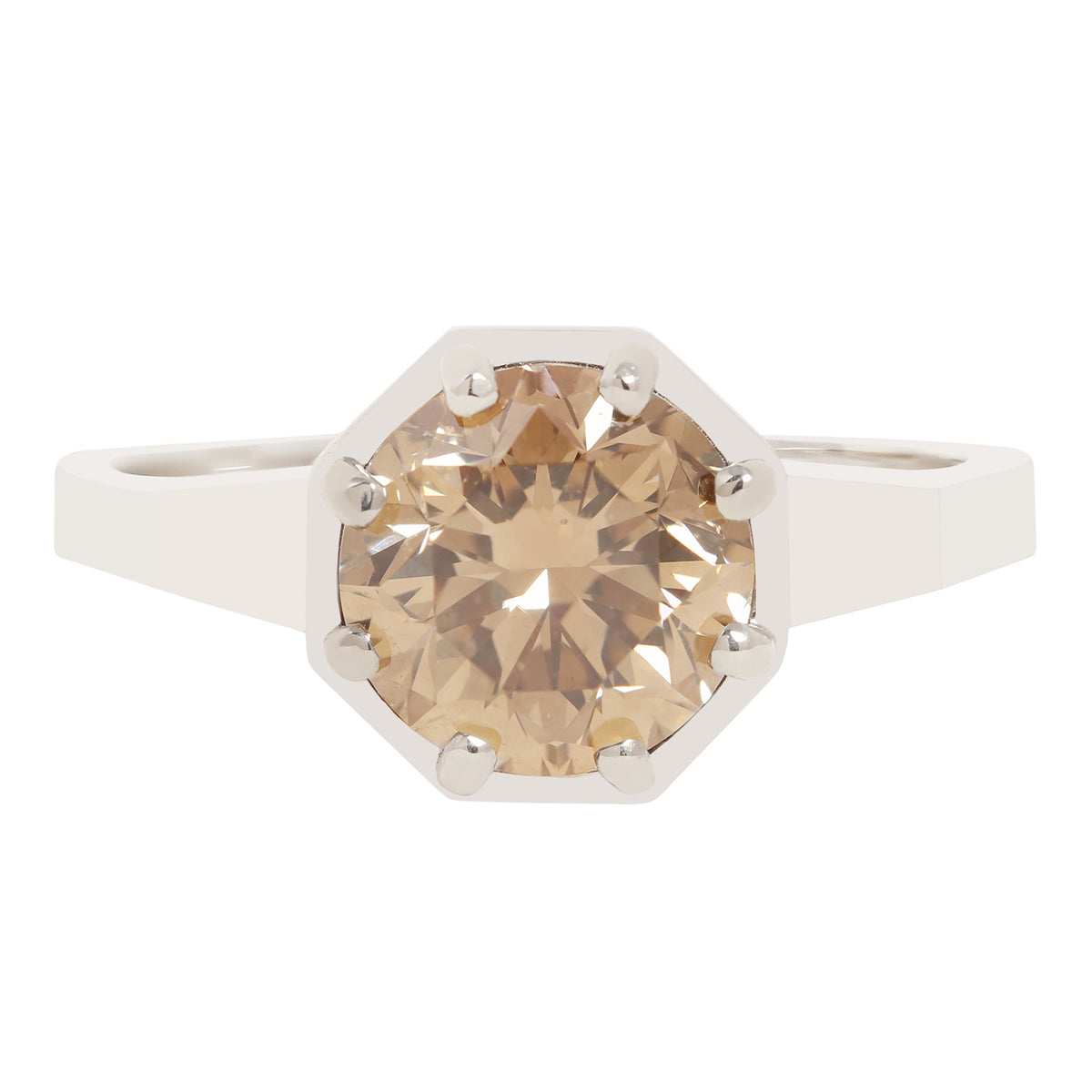An octagonal solitaire ring featuring a large, round-cut champagne-colored gemstone in a white metal setting with prong holds, shown against a plain white background.