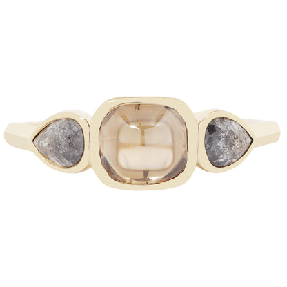 Gold ring with three stones on a white background