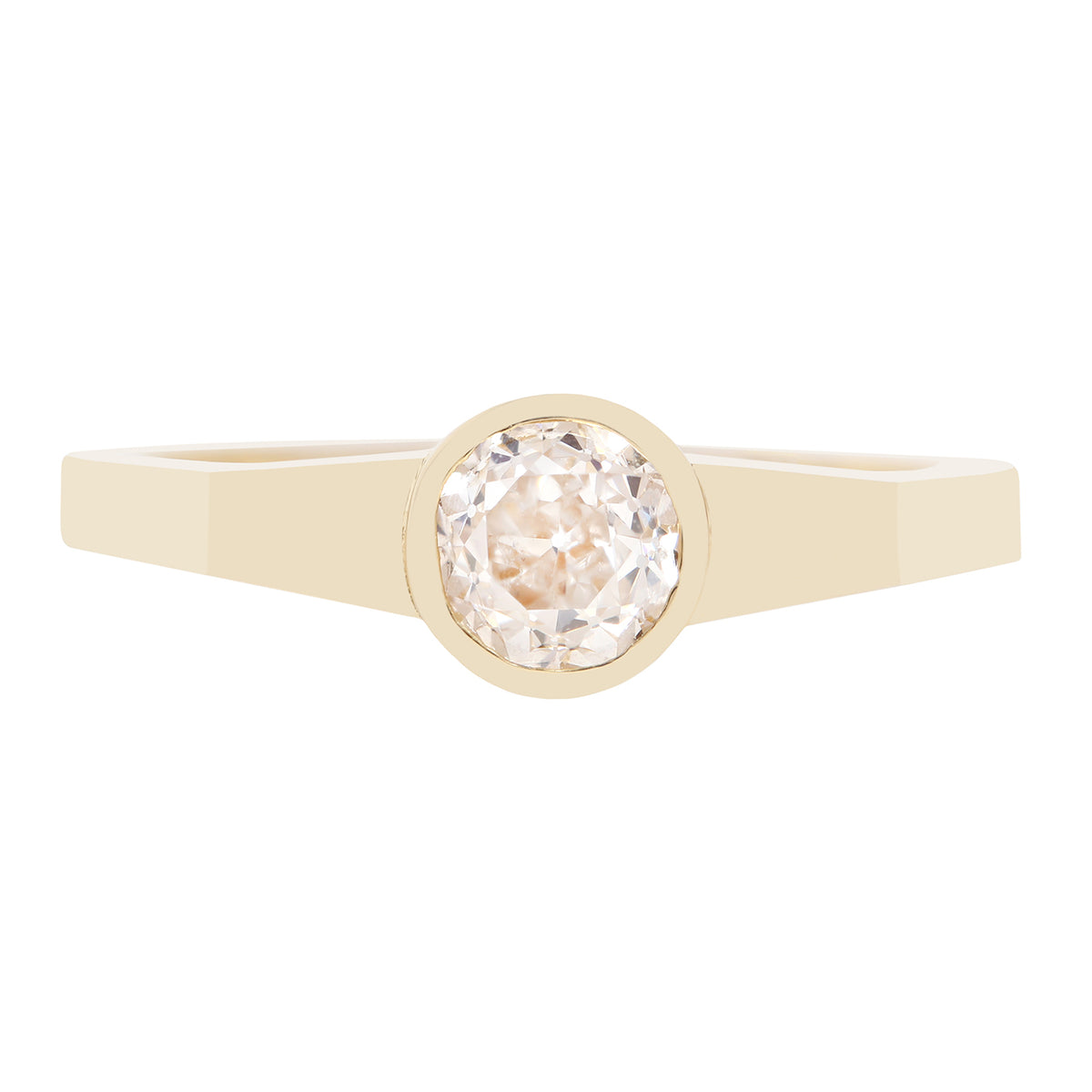 A minimalist yellow gold ring featuring a bezel-set round-cut clear diamond, presented on a solid white background.