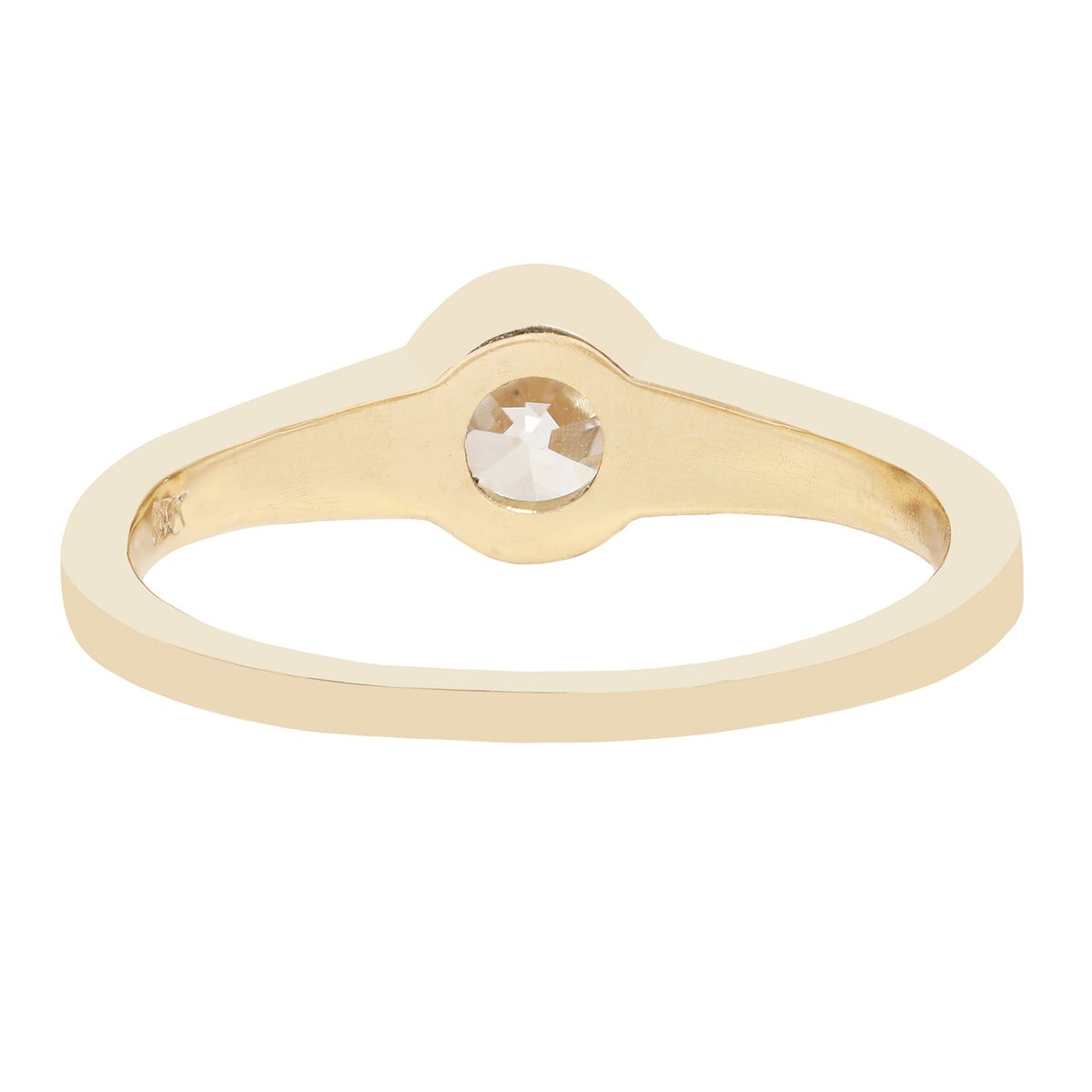 A minimalist yellow gold ring featuring a bezel-set round-cut clear diamond, presented on a solid white background.