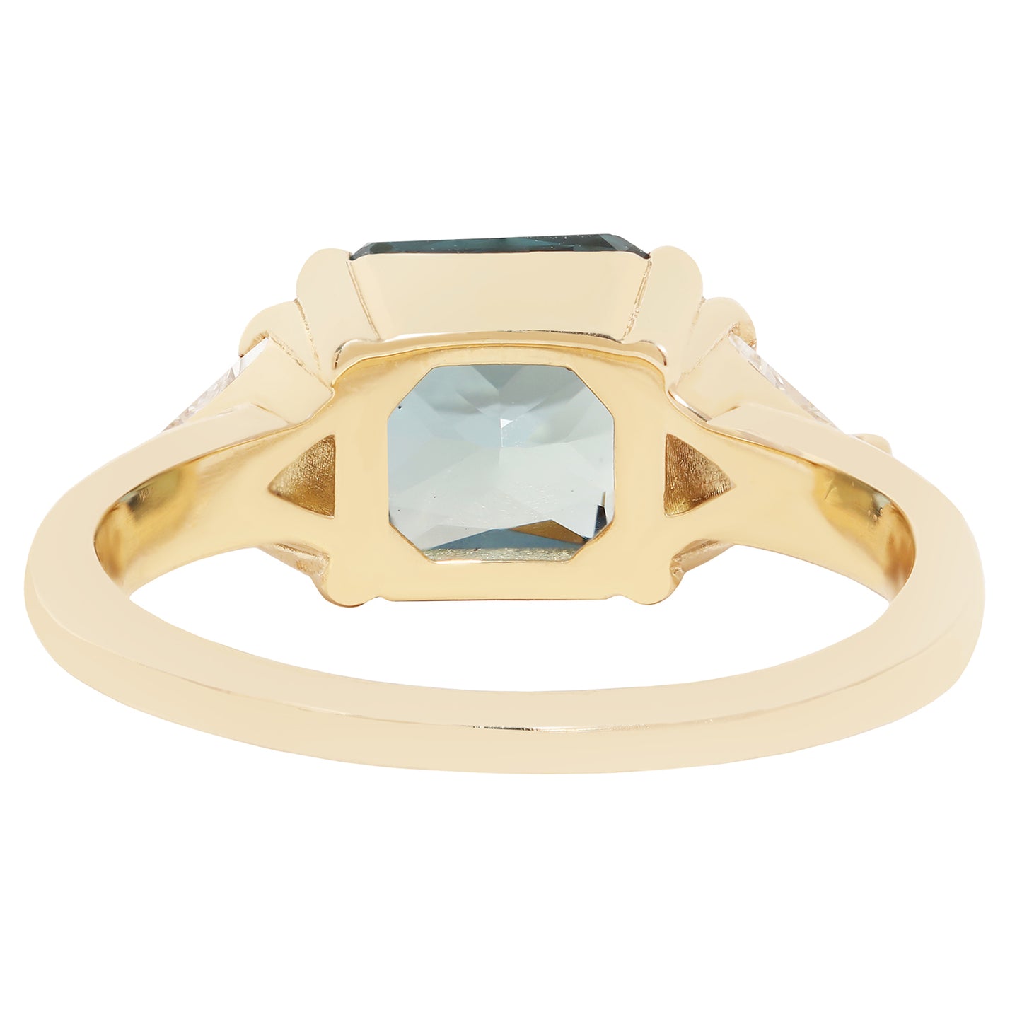A gold signet ring featuring a large, faceted light blue-gray rectangular gemstone, with smaller clear stones set in the shoulders, shown on a plain white background.