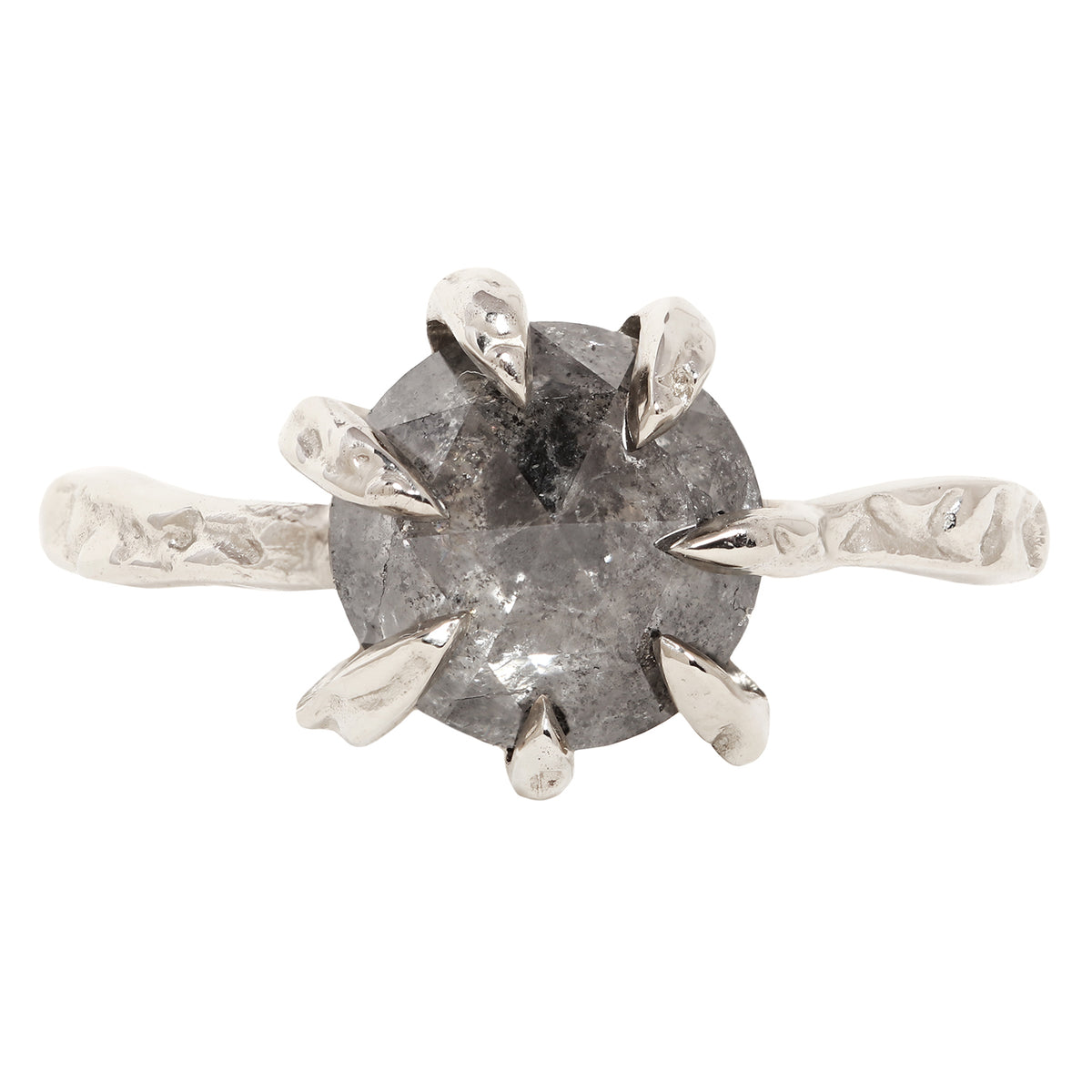 A unique white gold ring featuring a large, round, faceted gray gemstone held in a six-prong setting with textured, leaf-like prongs, mounted on a matching textured band.