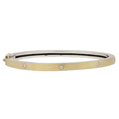 Rene Escobar - Gold bangle with embedded diamonds on a white background