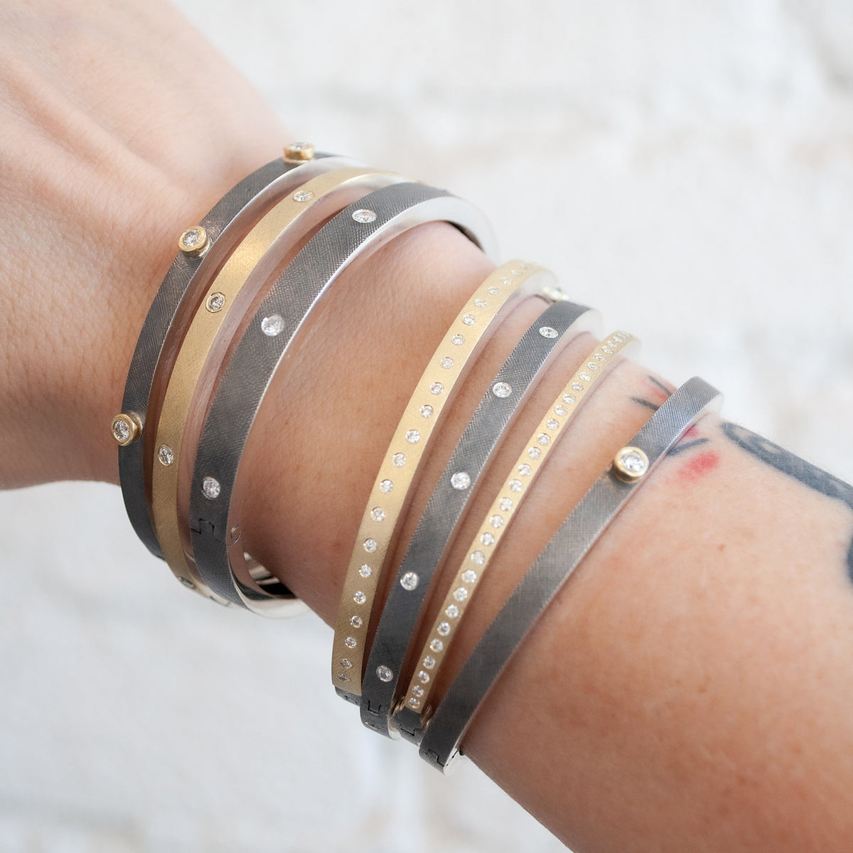 Rene Escobar - Close-up of a wrist wearing multiple bracelets with a blurred background