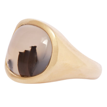 Gold ring with a brown stone on a white background