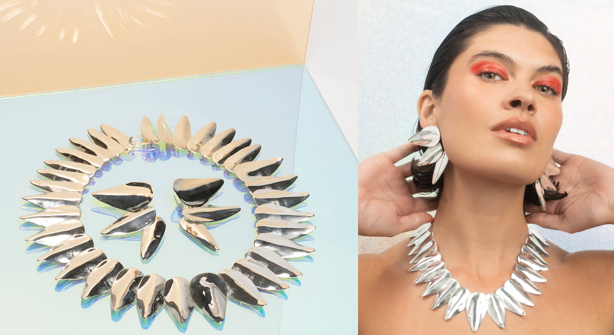 Jewelry set with a necklace and earrings on a light blue background, and shown on a model.