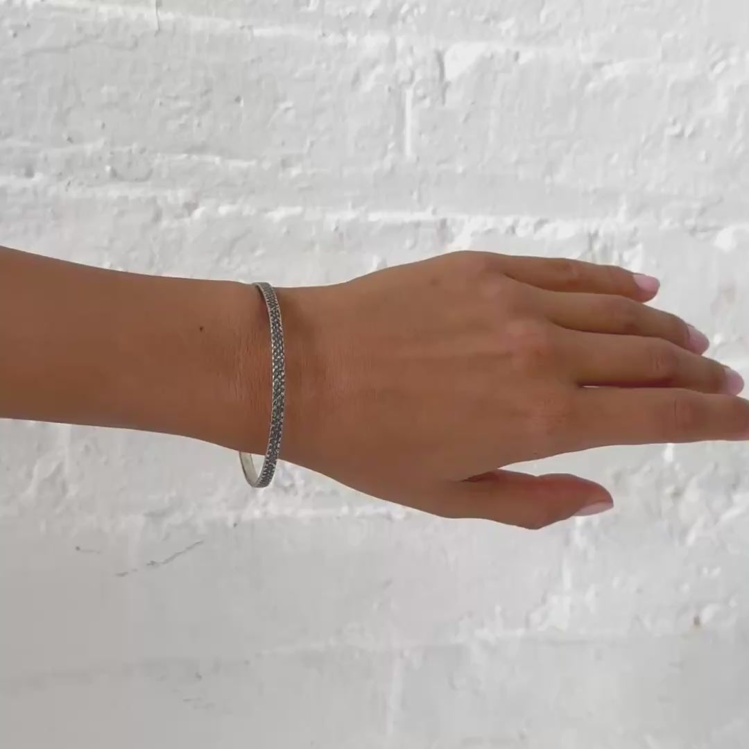 silver bangle with textured, oxidized finish worn on the wrist - Lauren Wolf Jewelry | ESQUELETO