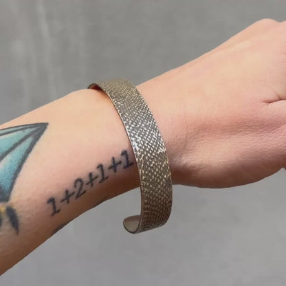 An oxidzed silver bangle with snakeskin texture pictured on the wrist - Lauren Wolf Jewelry | ESQUELETO 