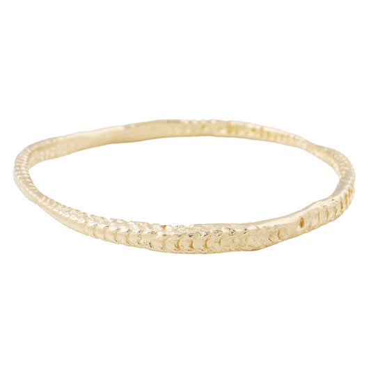 Textured gold bangle against a white background - Lauren Wolf Jewelry | ESQUELETO