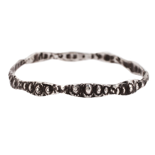 textured silver bangle with oxidized finish against a white background - Lauren Wolf Jewelry | ESQUELETO 