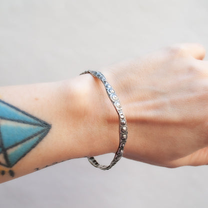 textured silver bangle with oxidized finish worn on wrist - Lauren Wolf Jewelry | ESQUELETO 