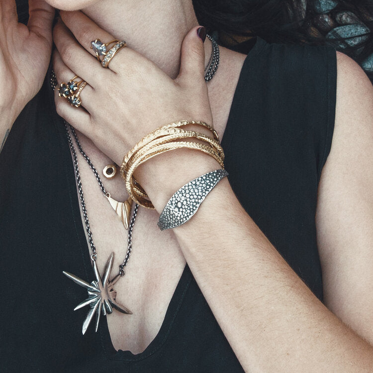 textured oxidized silver bangle styled on the wrist with other Lauren Wolf Jewelry bracelets and rings | ESQUELETO