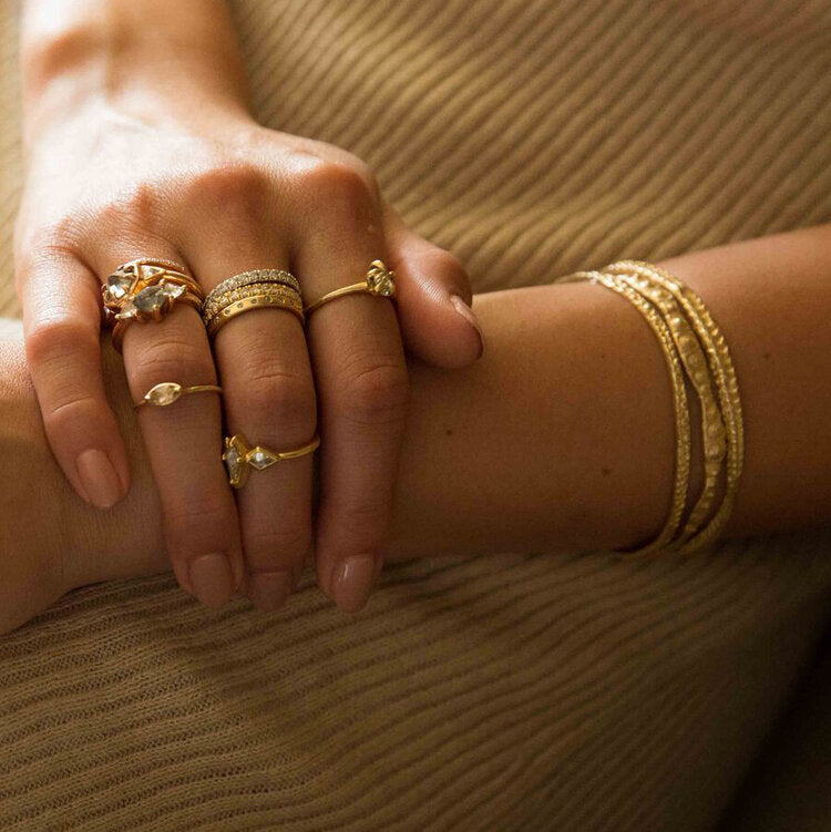 Sea urchin textured gold bangle from Lauren Wolf pictured on a wrist with other gold bangles from the artist | ESQUELETO 