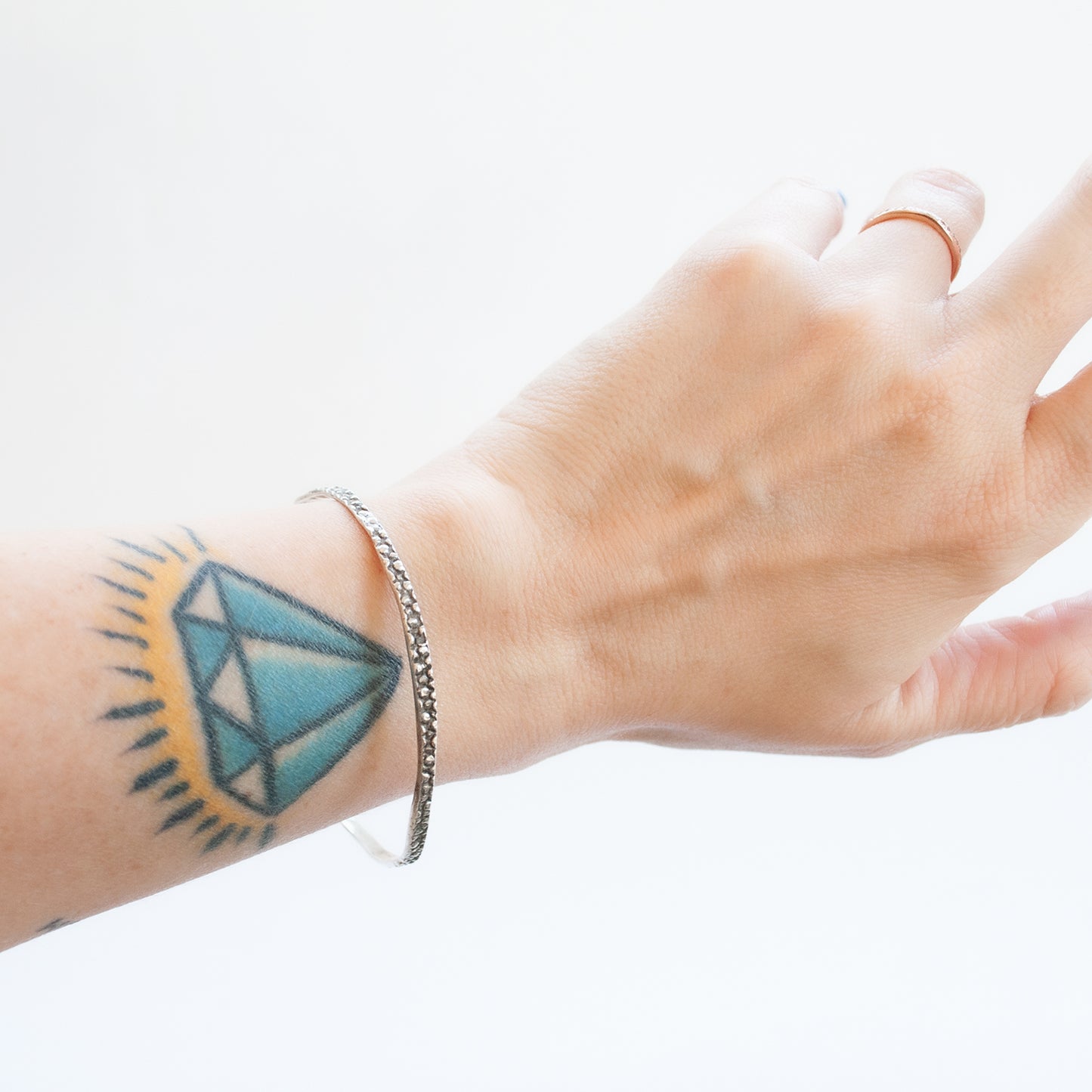The Silver Stingray Bangle by Lauren Wolf Jewelry shown on the wrist