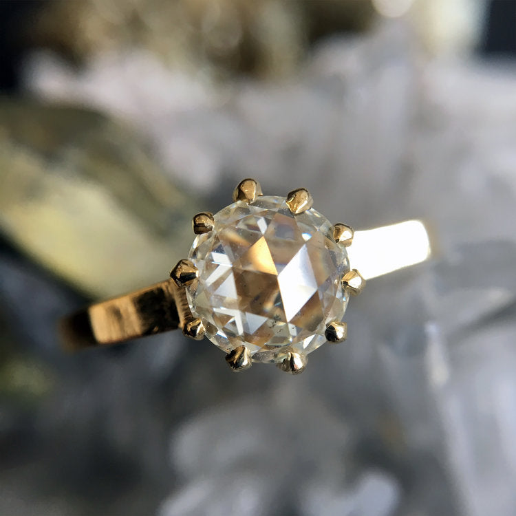 Lauren Wolf - Gold ring with a large diamond on a neutral background